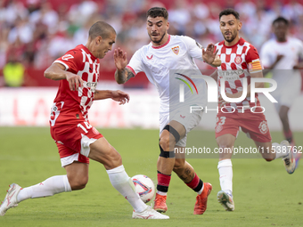 Isaac Romero of Sevilla FC competes for the ball with Oriol Romeu of Girona FC during the La Liga EA Sports match between Sevilla FC and Gir...