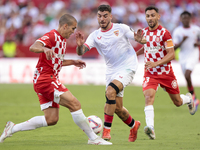 Isaac Romero of Sevilla FC competes for the ball with Oriol Romeu of Girona FC during the La Liga EA Sports match between Sevilla FC and Gir...