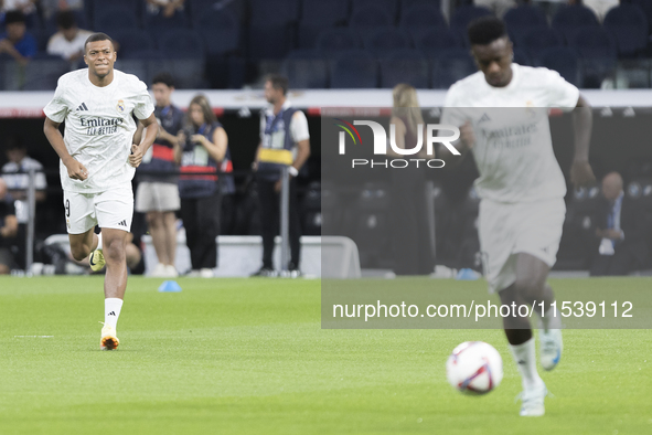 Vinicius Jr. of Real Madrid and Kylian Mbappe of Real Madrid warm up during the La Liga 2024/25 match between Real Madrid and Real Betis at...