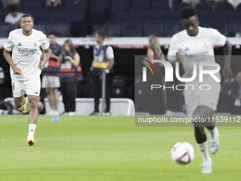 Vinicius Jr. of Real Madrid and Kylian Mbappe of Real Madrid warm up during the La Liga 2024/25 match between Real Madrid and Real Betis at...