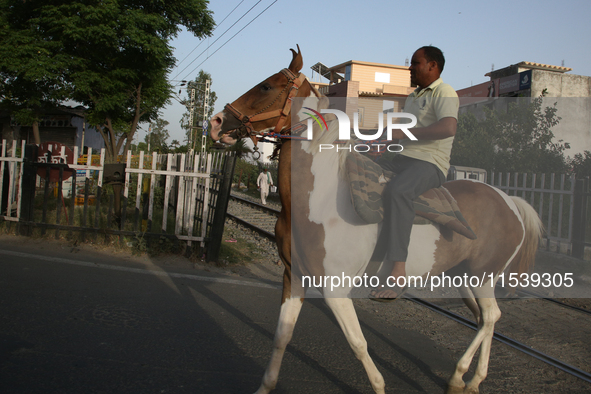 A man rides a horse in Bazpur, Uttarakhand, India, on April 19, 2024. 