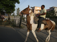 A man rides a horse in Bazpur, Uttarakhand, India, on April 19, 2024. (