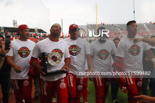 Robinson Cano #22 of Diablos Rojos holds the trophy after winning the South Zone 2024 championship series of the Mexican Baseball League (LM...