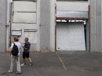 People pass warehouses damaged by a missile launched from the Russian Federation in City, Country, on September 2, 2024. (