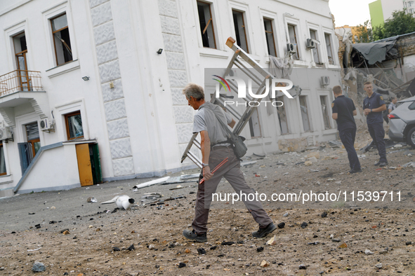 A man carries a ladder near a building on Beresteiskyi Avenue damaged by the Russian missile attack in Kyiv, Ukraine, on September 2, 2024....