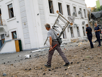 A man carries a ladder near a building on Beresteiskyi Avenue damaged by the Russian missile attack in Kyiv, Ukraine, on September 2, 2024....