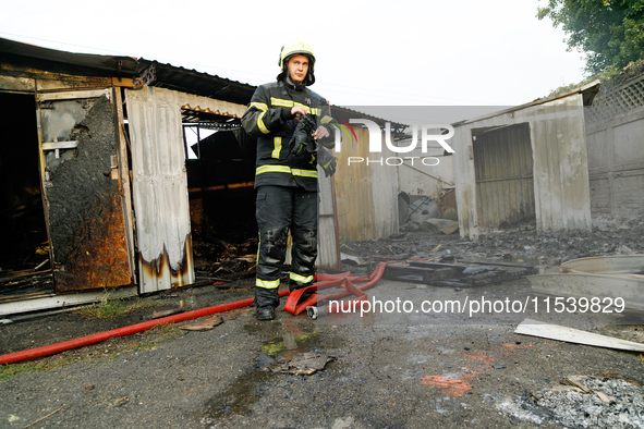 A firefighter stands at a burnt-out recycling station in the Sviatoshynskyi district damaged by the Russian missile attack in Kyiv, Ukraine,...