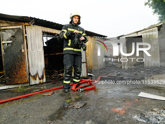 A firefighter stands at a burnt-out recycling station in the Sviatoshynskyi district damaged by the Russian missile attack in Kyiv, Ukraine,...