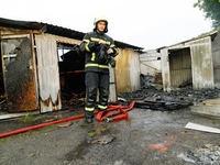 A firefighter stands at a burnt-out recycling station in the Sviatoshynskyi district damaged by the Russian missile attack in Kyiv, Ukraine,...