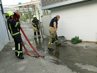 Firefighters roll hoses after putting out a fire at a recycling point in the Sviatoshynskyi district damaged by the Russian missile attack i...