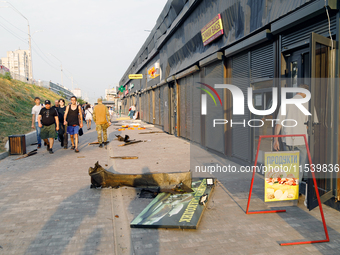 People walk past shops in the Sviatoshynskyi district damaged by the Russian missile attack in Kyiv, Ukraine, on September 2, 2024. NO USE R...