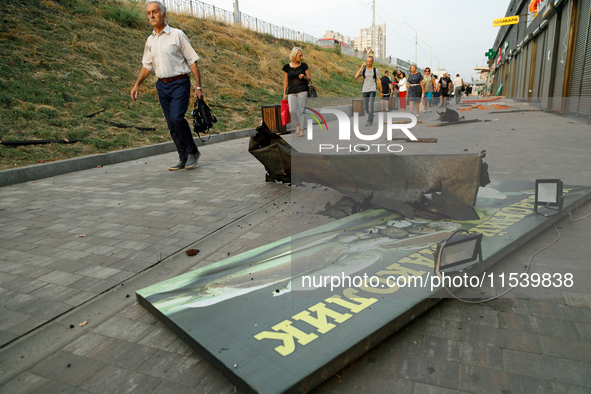 People walk past shops in the Sviatoshynskyi district damaged by the Russian missile attack in Kyiv, Ukraine, on September 2, 2024. NO USE R...