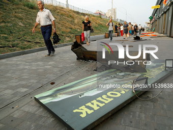 People walk past shops in the Sviatoshynskyi district damaged by the Russian missile attack in Kyiv, Ukraine, on September 2, 2024. NO USE R...