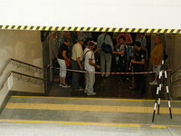 People stay at one of the entrances of the underground passage at the Sviatoshyn metro station in the Sviatoshynskyi district, closed after...