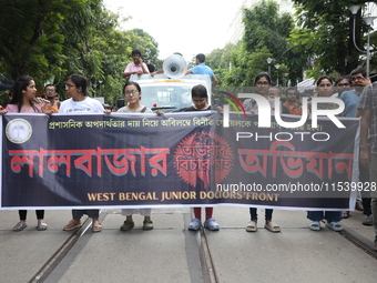 Medical students and doctors shout slogans during a protest rally towards Kolkata Police Headquarters, Lalbazar, protesting against the rape...