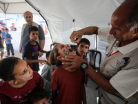 A Palestinian child receives a polio vaccination in the UK-MED field hospital in Zawayda, Gaza Strip, on September 2, 2024, amid the ongoing...