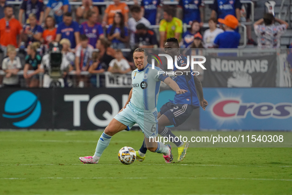 Cincinnati midfielder Obinna Nwobodo and Montreal midfielder Samuel Piette compete for the ball during the Major League Soccer match between...