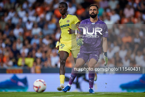 Giorgi Mamardashvili of Valencia CF is in action next to Thierno Barry of Villarreal CF during the LaLiga EA Sports match between Valencia C...