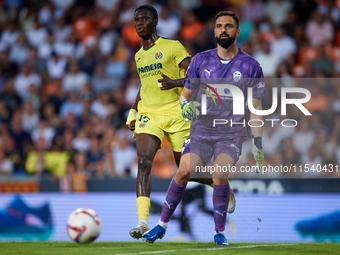 Giorgi Mamardashvili of Valencia CF is in action next to Thierno Barry of Villarreal CF during the LaLiga EA Sports match between Valencia C...