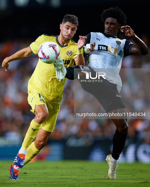 Santi Comesana Veiga of Villarreal CF competes for the ball with Thierry Rendall of Valencia CF during the LaLiga EA Sports match between Va...