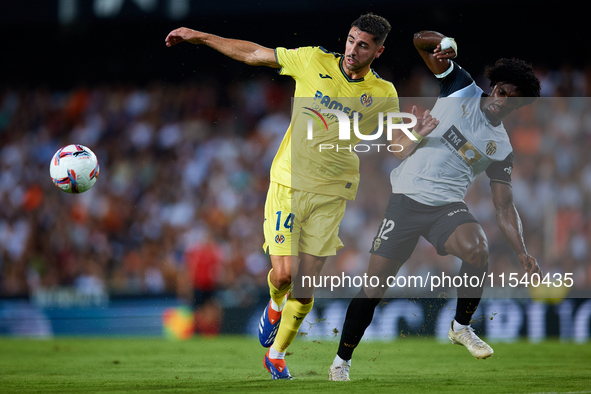 Santi Comesana Veiga of Villarreal CF competes for the ball with Thierry Rendall of Valencia CF during the LaLiga EA Sports match between Va...