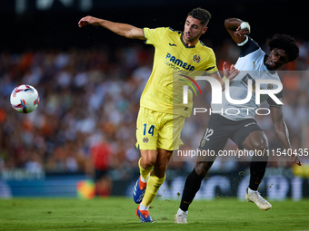 Santi Comesana Veiga of Villarreal CF competes for the ball with Thierry Rendall of Valencia CF during the LaLiga EA Sports match between Va...