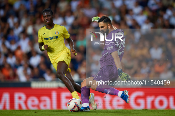 Giorgi Mamardashvili of Valencia CF competes for the ball with Thierno Barry of Villarreal CF during the LaLiga EA Sports match between Vale...