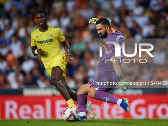 Giorgi Mamardashvili of Valencia CF competes for the ball with Thierno Barry of Villarreal CF during the LaLiga EA Sports match between Vale...