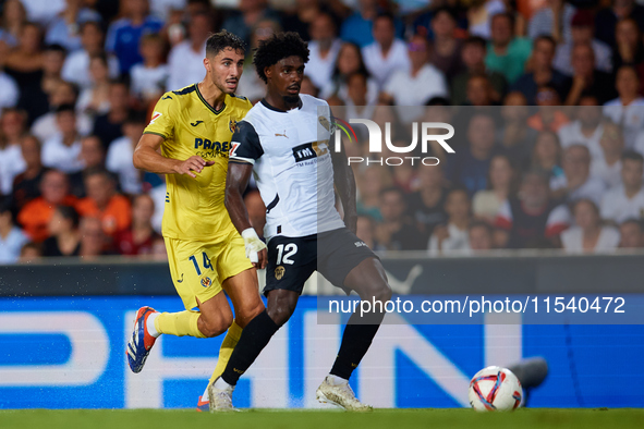 Thierry Rendall (R) of Valencia CF competes for the ball with Santi Comesana Veiga of Villarreal CF during the LaLiga EA Sports match betwee...