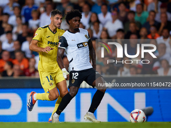 Thierry Rendall (R) of Valencia CF competes for the ball with Santi Comesana Veiga of Villarreal CF during the LaLiga EA Sports match betwee...