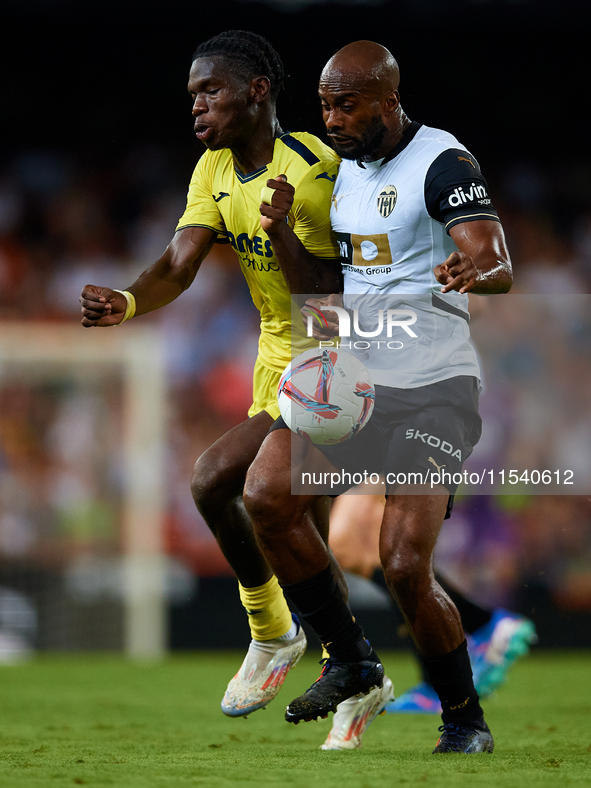 Dimitri Foulquier (R) of Valencia CF competes for the ball with Thierno Barry of Villarreal CF during the LaLiga EA Sports match between Val...