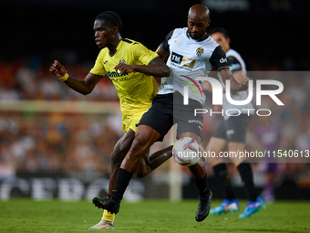 Dimitri Foulquier (R) of Valencia CF competes for the ball with Thierno Barry of Villarreal CF during the LaLiga EA Sports match between Val...