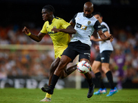 Dimitri Foulquier (R) of Valencia CF competes for the ball with Thierno Barry of Villarreal CF during the LaLiga EA Sports match between Val...