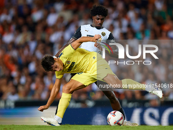 Ramon Terrats of Villarreal CF competes for the ball with Thierry Rendall of Valencia CF during the LaLiga EA Sports match between Valencia...