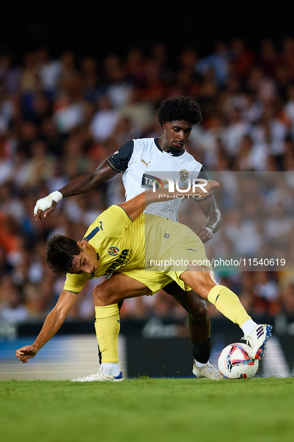 Ramon Terrats of Villarreal CF competes for the ball with Thierry Rendall of Valencia CF during the LaLiga EA Sports match between Valencia...