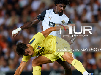 Ramon Terrats of Villarreal CF competes for the ball with Thierry Rendall of Valencia CF during the LaLiga EA Sports match between Valencia...