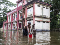 A child collects drinking water from a half-submerged tubewell in front of a shelter in Sonapur Union of Sonaimuri Upazila in Noakhali Distr...