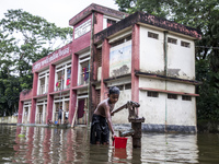 A child collects drinking water from a half-submerged tubewell in front of a shelter in Sonapur Union of Sonaimuri Upazila in Noakhali Distr...