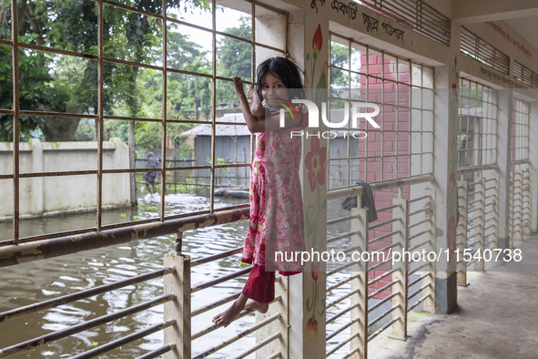 A small child stands on the balcony of a flood shelter in Sonapur Union, Sonaimuri Upazila, Noakhali District, Chittagong Division, Banglade...