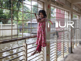 A small child stands on the balcony of a flood shelter in Sonapur Union, Sonaimuri Upazila, Noakhali District, Chittagong Division, Banglade...