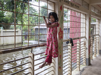 A small child stands on the balcony of a flood shelter in Sonapur Union, Sonaimuri Upazila, Noakhali District, Chittagong Division, Banglade...