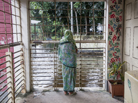 An elderly woman stands on the balcony looking out at the floodwaters of a flood shelter in Sonapur Union, Sonaimuri Upazila, Noakhali Distr...