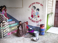 A woman cooks rice with a gas stove at a flood shelter in Sonapur Union, Sonaimuri Upazila, Noakhali District, Chittagong Division, Banglade...