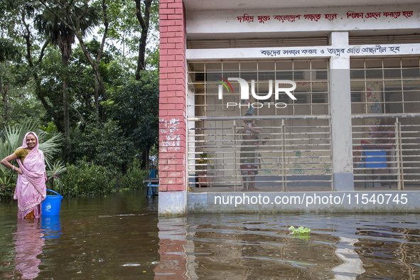 Some children stand on the balcony after taking shelter in a school due to floods in Sonapur Union of Sonaimuri Upazila of Noakhali District...