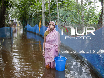 An elderly woman stands in knee-deep flood water in Sonapur Union of Sonaimuri Upazila of Noakhali District of Chittagong Division in Noakha...