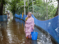 An elderly woman stands in knee-deep flood water in Sonapur Union of Sonaimuri Upazila of Noakhali District of Chittagong Division in Noakha...