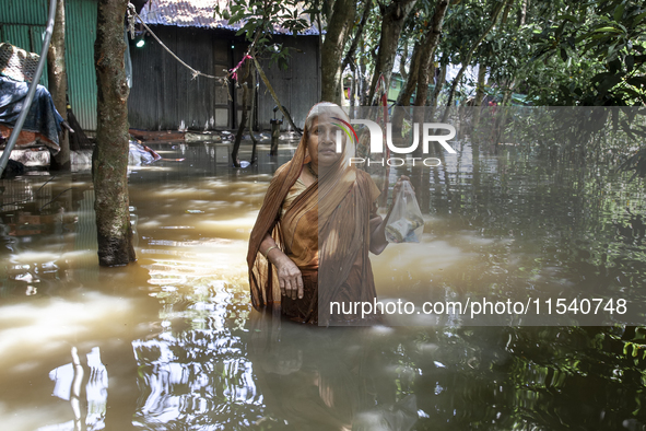 An elderly woman stands in waist-deep flood water in a village of Sonapur Union in Sonaimuri Upazila of Noakhali District of Chittagong Divi...