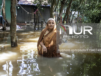 An elderly woman stands in waist-deep flood water in a village of Sonapur Union in Sonaimuri Upazila of Noakhali District of Chittagong Divi...