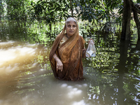 An elderly woman stands in waist-deep flood water in a village of Sonapur Union in Sonaimuri Upazila of Noakhali District of Chittagong Divi...