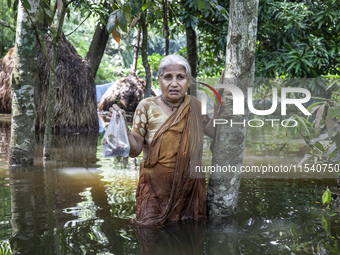 An elderly woman stands in waist-deep flood water in a village of Sonapur Union in Sonaimuri Upazila of Noakhali District of Chittagong Divi...